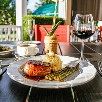 Dish of steak, mashed potatoes, asparagus, and a glass of red wine
