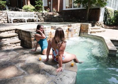 Woman and man enjoying food and champagne by an indoor jacuzzi